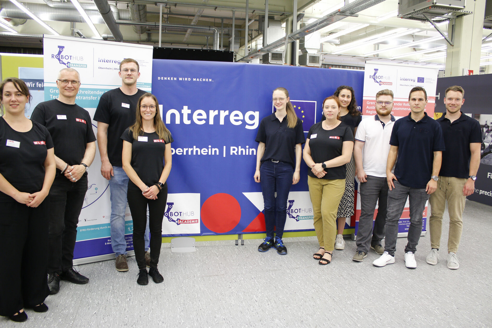 Eine Gruppe von Menschen mit dem Interreg-Logo im Hintergrund