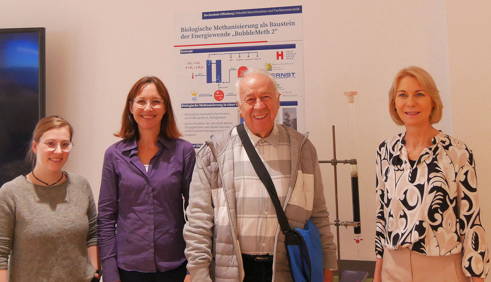 Drei Frauen und ein MAnn stehen vor einem Poster in der Zukunftswerkstatt