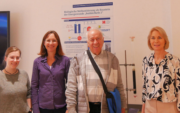 Drei Frauen und ein MAnn stehen vor einem Poster in der Zukunftswerkstatt