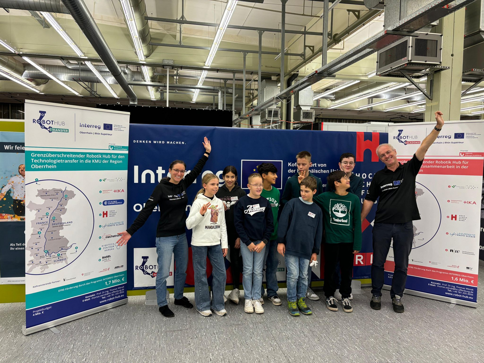 Ein Gruppenfoto von einem Mann, einer Frau und Kindern in einer Industriehalle