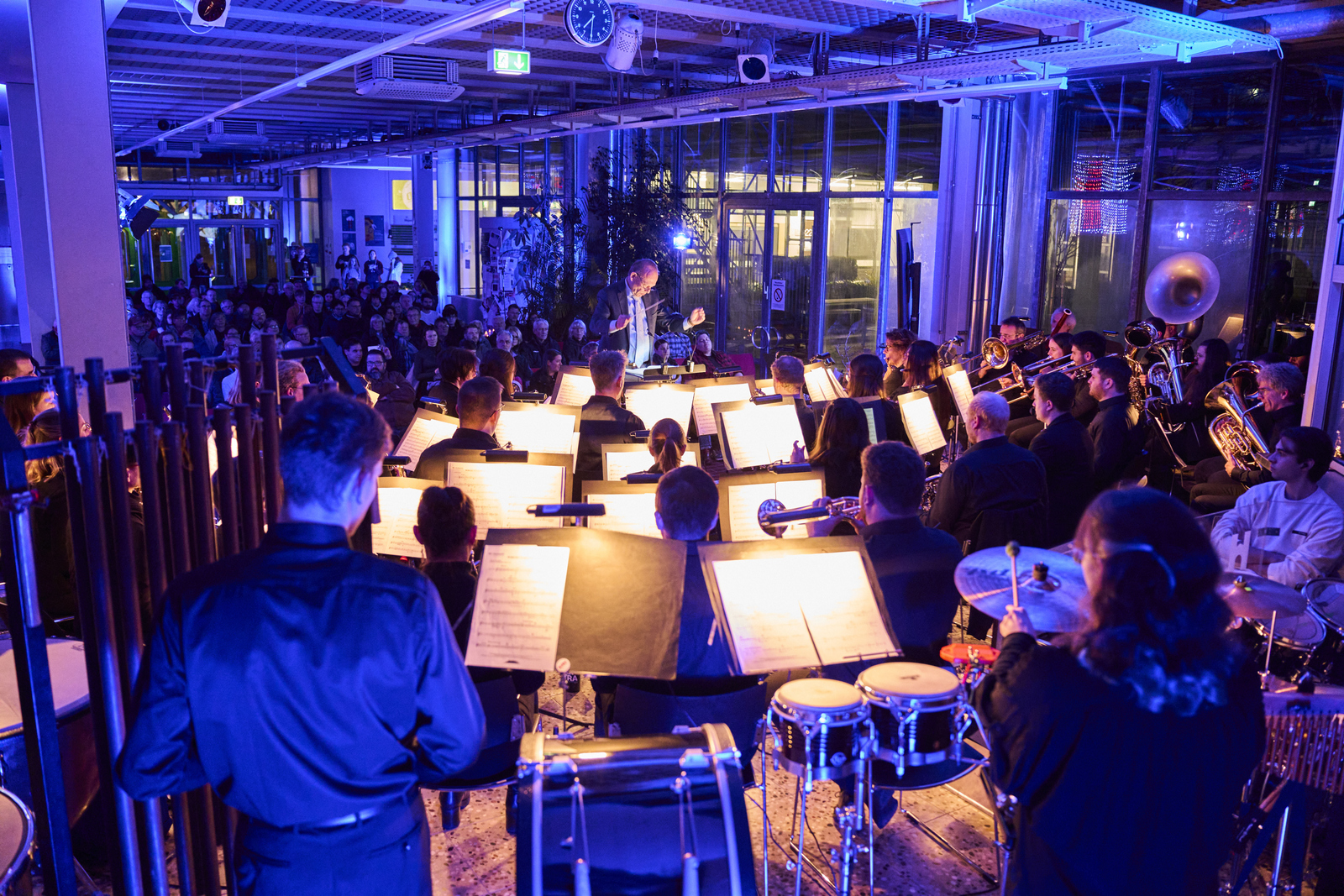 Blick von hinten über das Orchester und den Dirigenten hinweg auf das Publikum