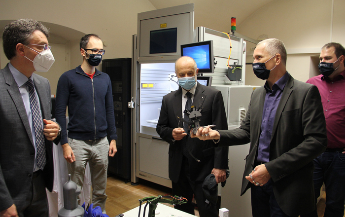 Prof. Dr. Thomas Wendt (2.v.r.) und die beiden Doktoranden Nikolai Hangst (r.) und Philipp Gawron (2.v.l.) erklärten Bürgermeister Thorsten Erny (l.) und Rektor Prof. Dr. Winfried Lieber (Mitte) vor dem neuen 3D-Drucker was mit diesem in Sachen Forschung alles möglich ist.