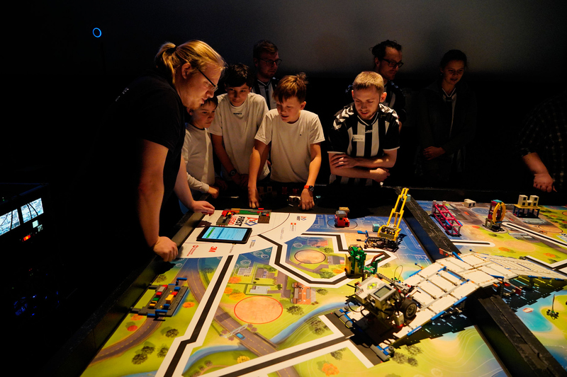 Gruppe von Lego League Mitspielern am Wettbewerbstisch